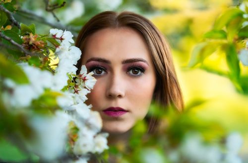 Free A captivating close-up portrait of a woman surrounded by spring blossoms in Victoria, BC. Stock Photo