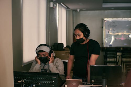 Two Men Wearing Headphones and Face Masks