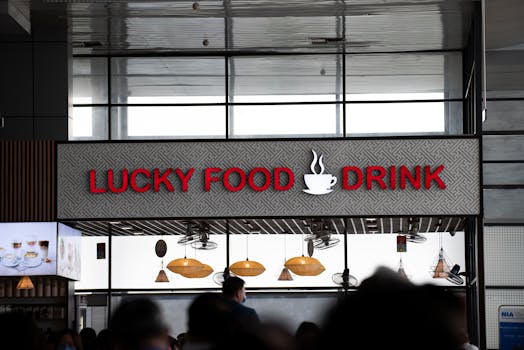Signage for Lucky Food Drink inside a bustling indoor setting, offering food and beverages.