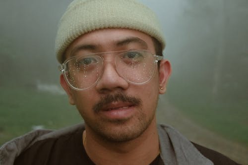 Close-Up Shot of a Bearded Man Wearing Eyeglasses and a Beanie