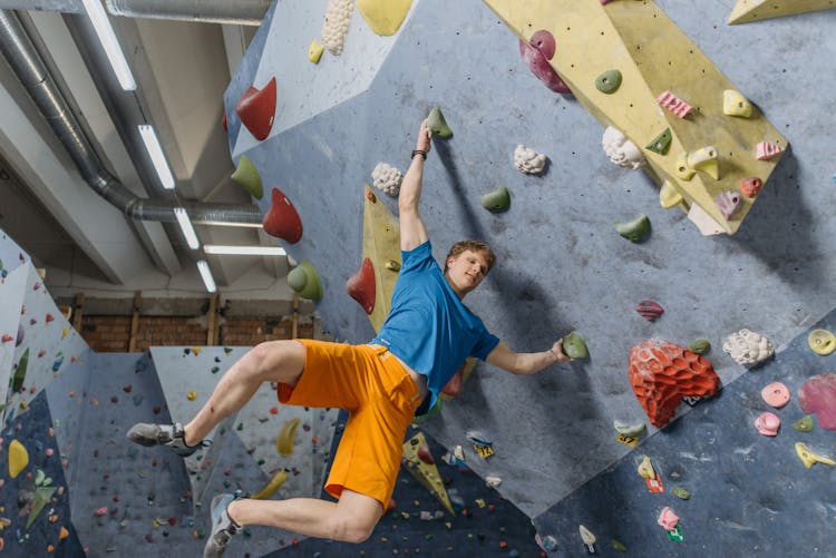 A Man Hanging From A Rock Wall