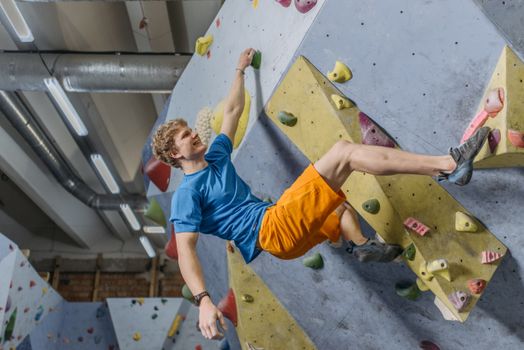 A Man Holding on a Rock Wall Smiling