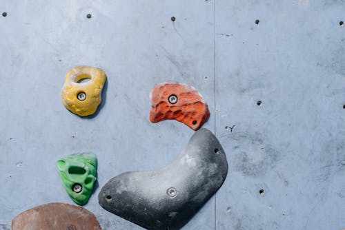 Colorful Climbing Holds on Gray Wall 