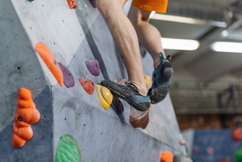 Free Close-Up Shot of a Person Wearing Shoes while Climbing on Rock Wall Stock Photo
