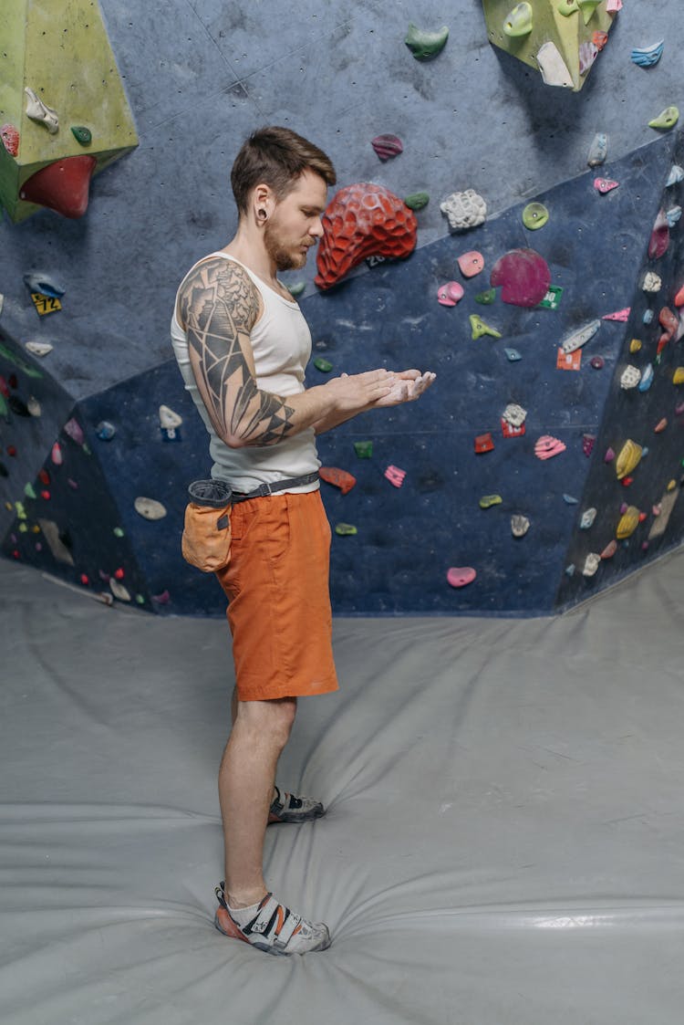 A Rock Climber Applying Chalk On His Hands