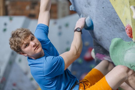 Young caucasian man bouldering indoors, focused challenge.
