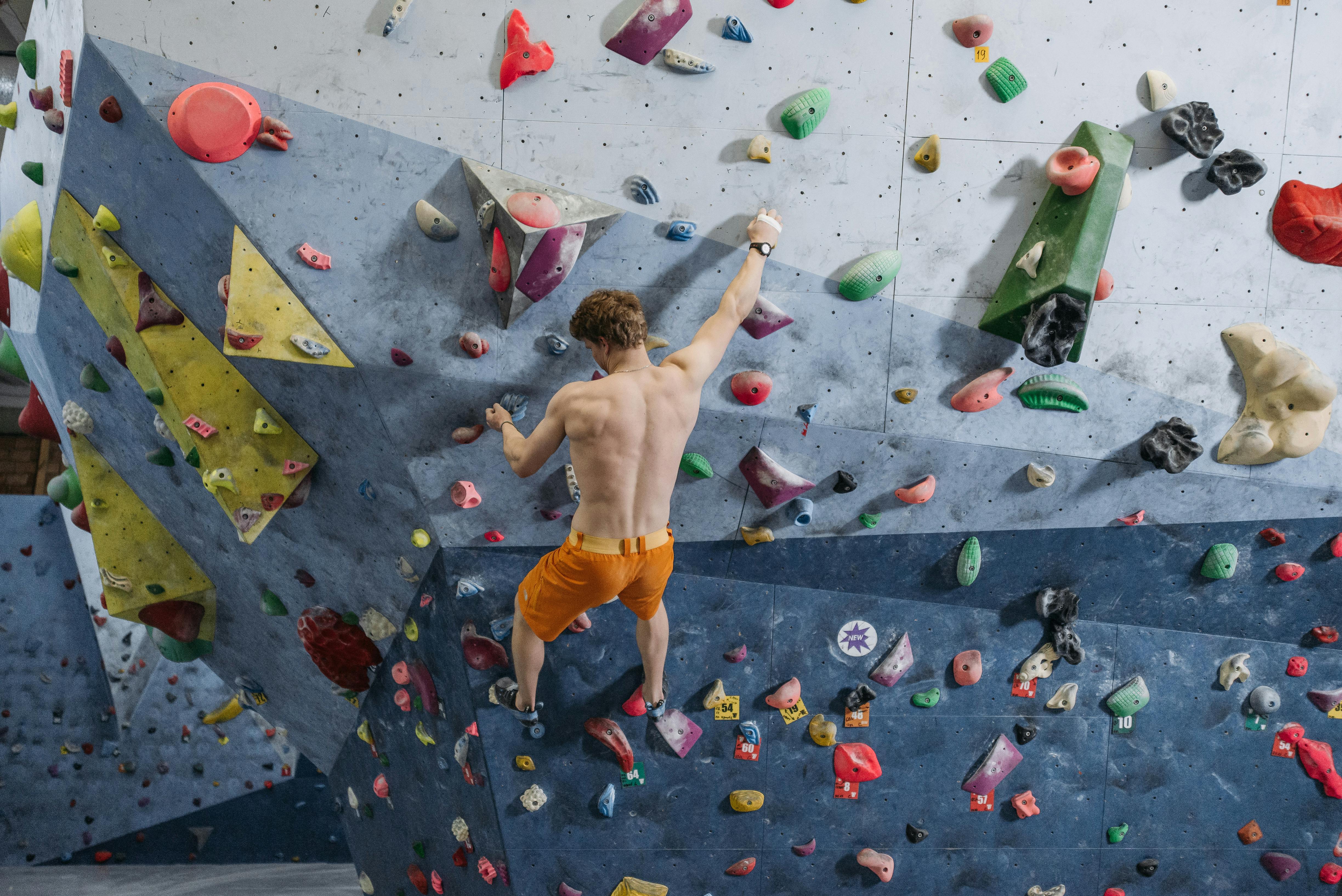 A Shirtless Man Climbing a Climbing Wall · Free Stock Photo