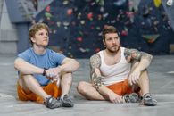 Man in Orange Tank Top Sitting Beside Boy in Blue Crew Neck T-shirt
