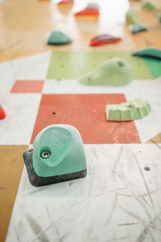 Close-up of a colorful climbing wall showing various grips and handholds for wall climbing.