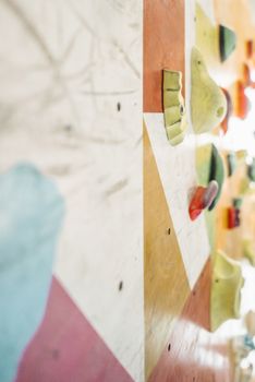 Close-up of a vibrant indoor climbing wall featuring various colored grips, perfect for climbers.