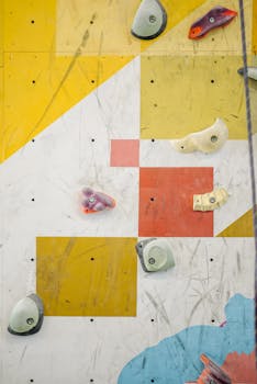 A close-up of a vibrant indoor climbing wall with geometric patterns and holds.