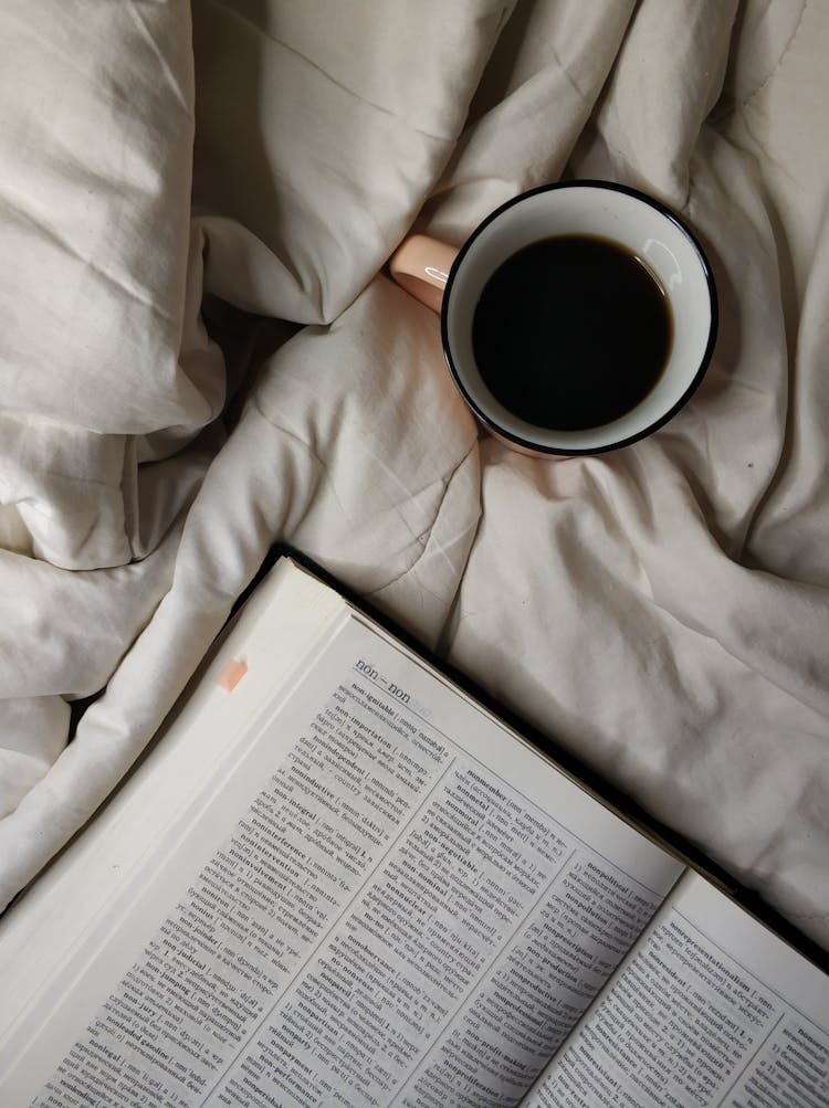 A Cup Of Black Coffee Near A Dictionary Book