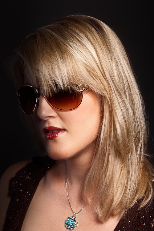 Close-Up Photo of a Woman with Blond Hair Wearing Brown Sunglasses
