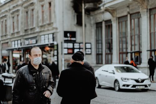 Free A city street scene with people wearing masks, highlighting urban life during the pandemic. Stock Photo