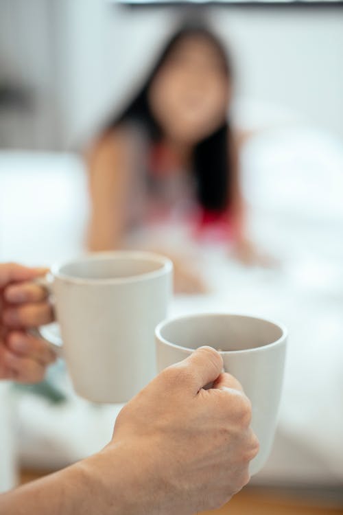 Free Crop man brining cups for drinking tea with girlfriend Stock Photo