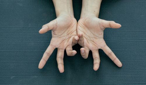 Free Top view of crop anonymous person showing palms of hands with curved fingers on green surface Stock Photo