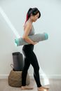 Serious woman holding rolled mat