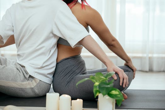 A couple practicing yoga together indoors, focusing on flexibility and mindfulness.