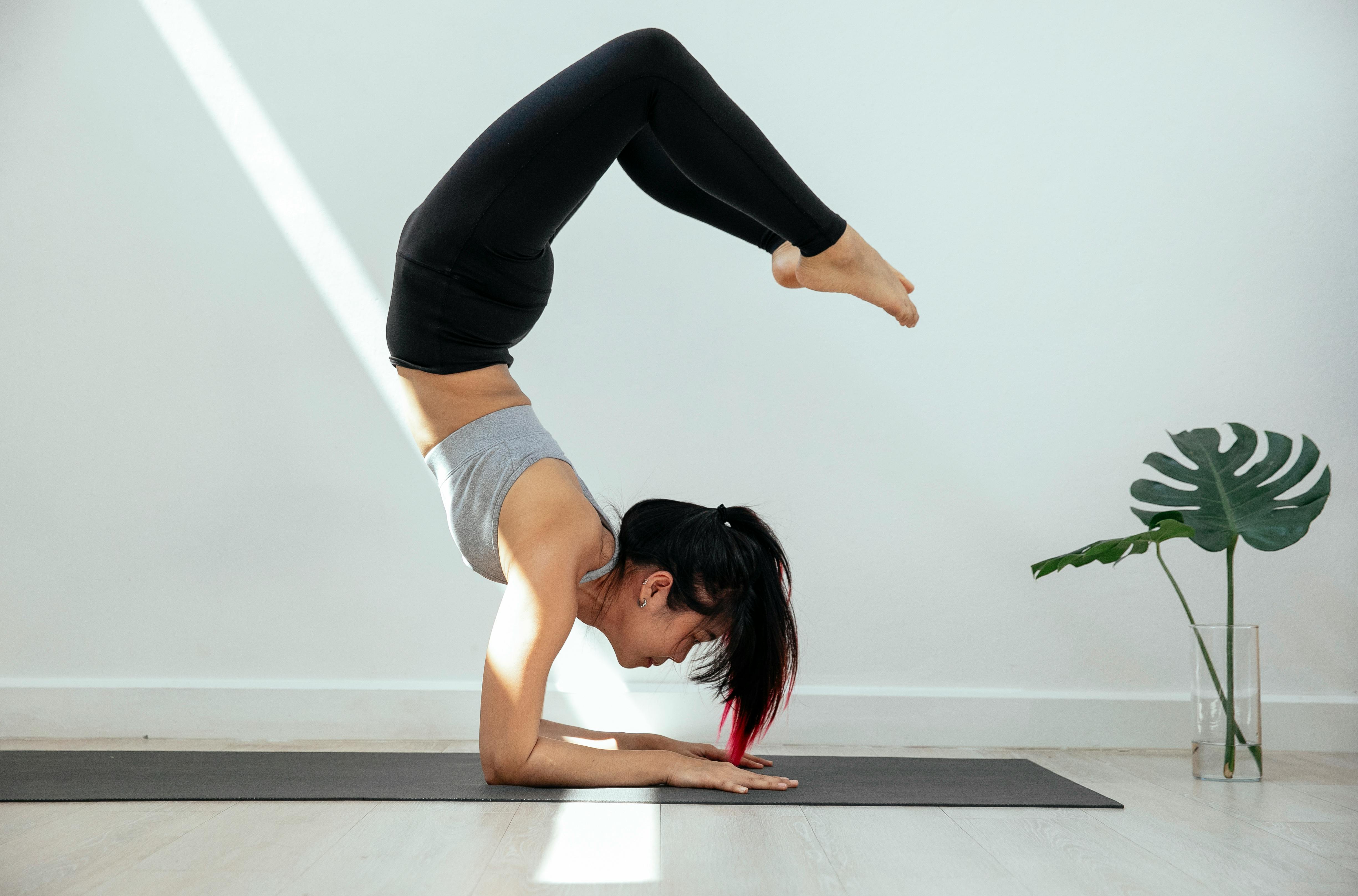 flexible woman doing scorpion yoga asana