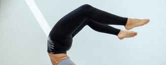 Crop slim woman doing yoga exercise