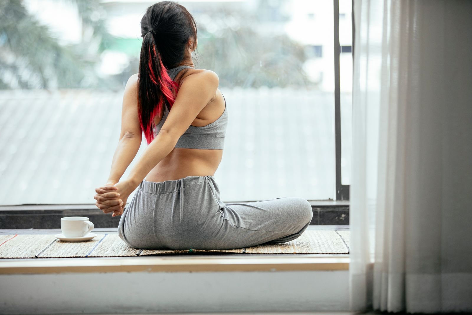 Person sitting upright at a bright desk with lower back posture support focus