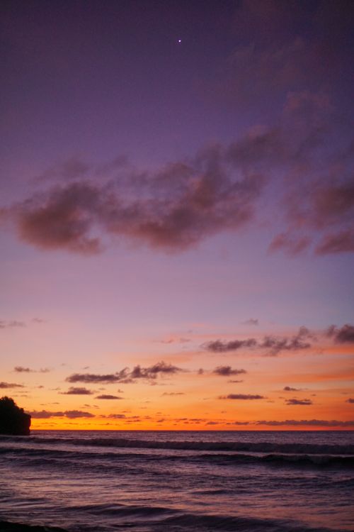 Free Vibrant sunset at Bali's coastline with a stunning blend of colors and peaceful ocean view. Stock Photo