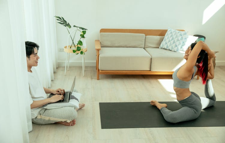 Woman Doing Yoga In Front Of Man