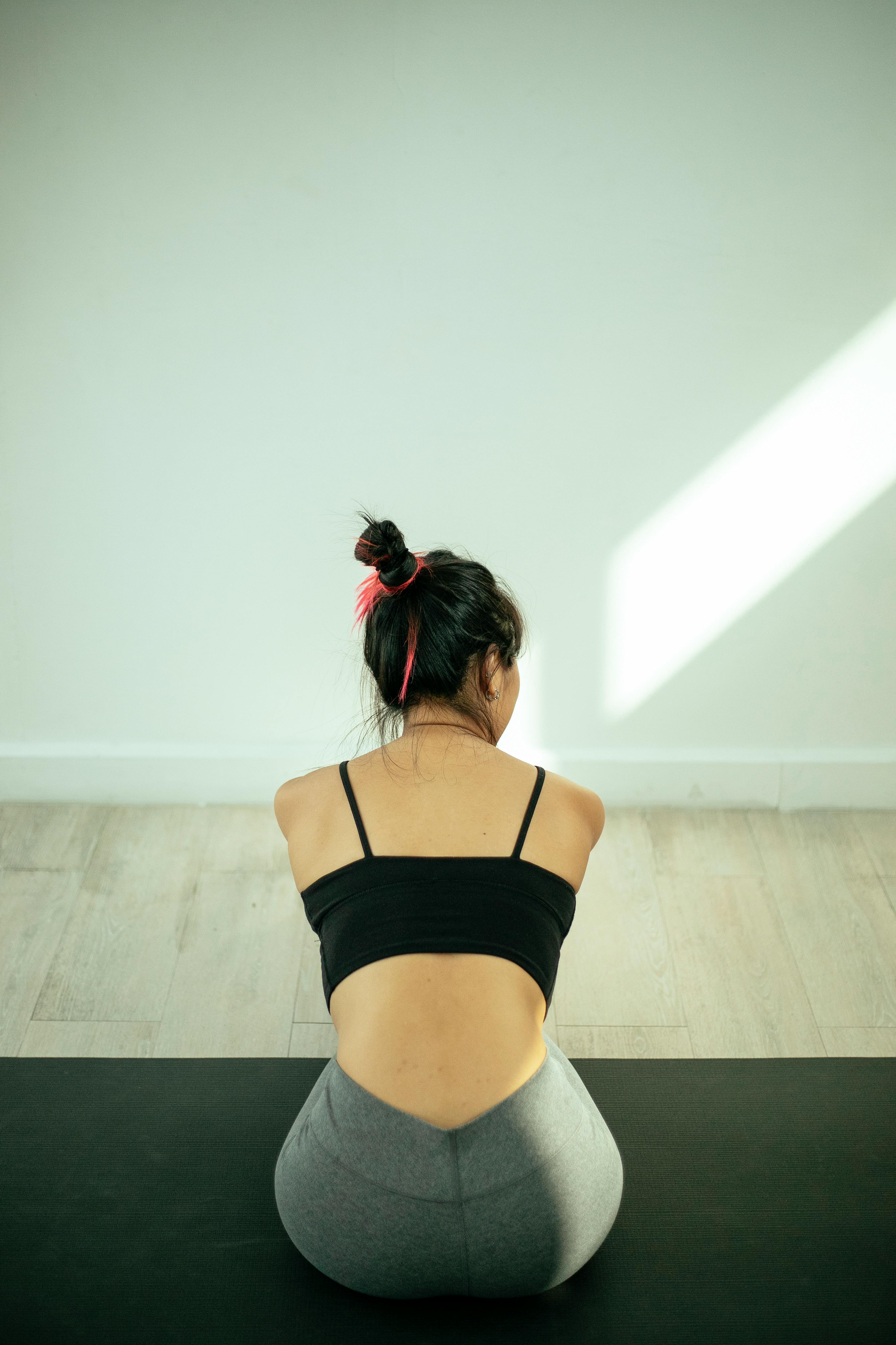 Back View of a Woman Sitting on Yoga Mat