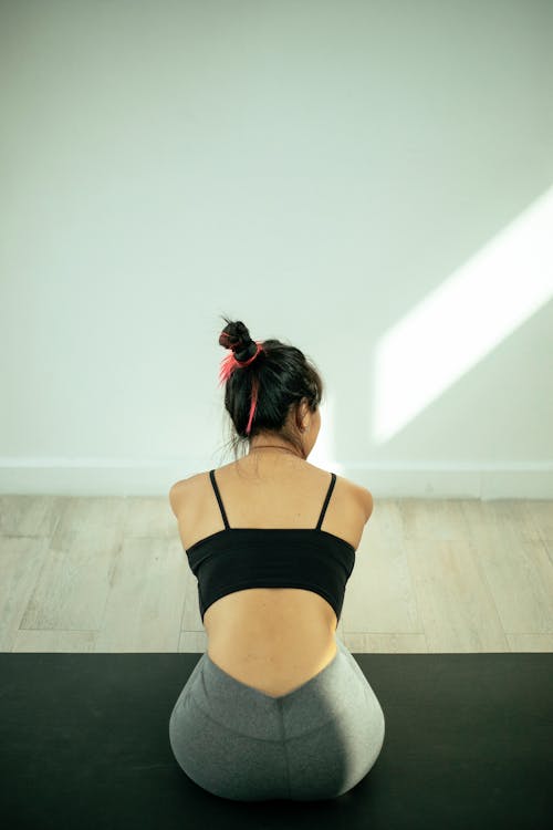 Free Back View of a Woman Sitting on Yoga Mat Stock Photo