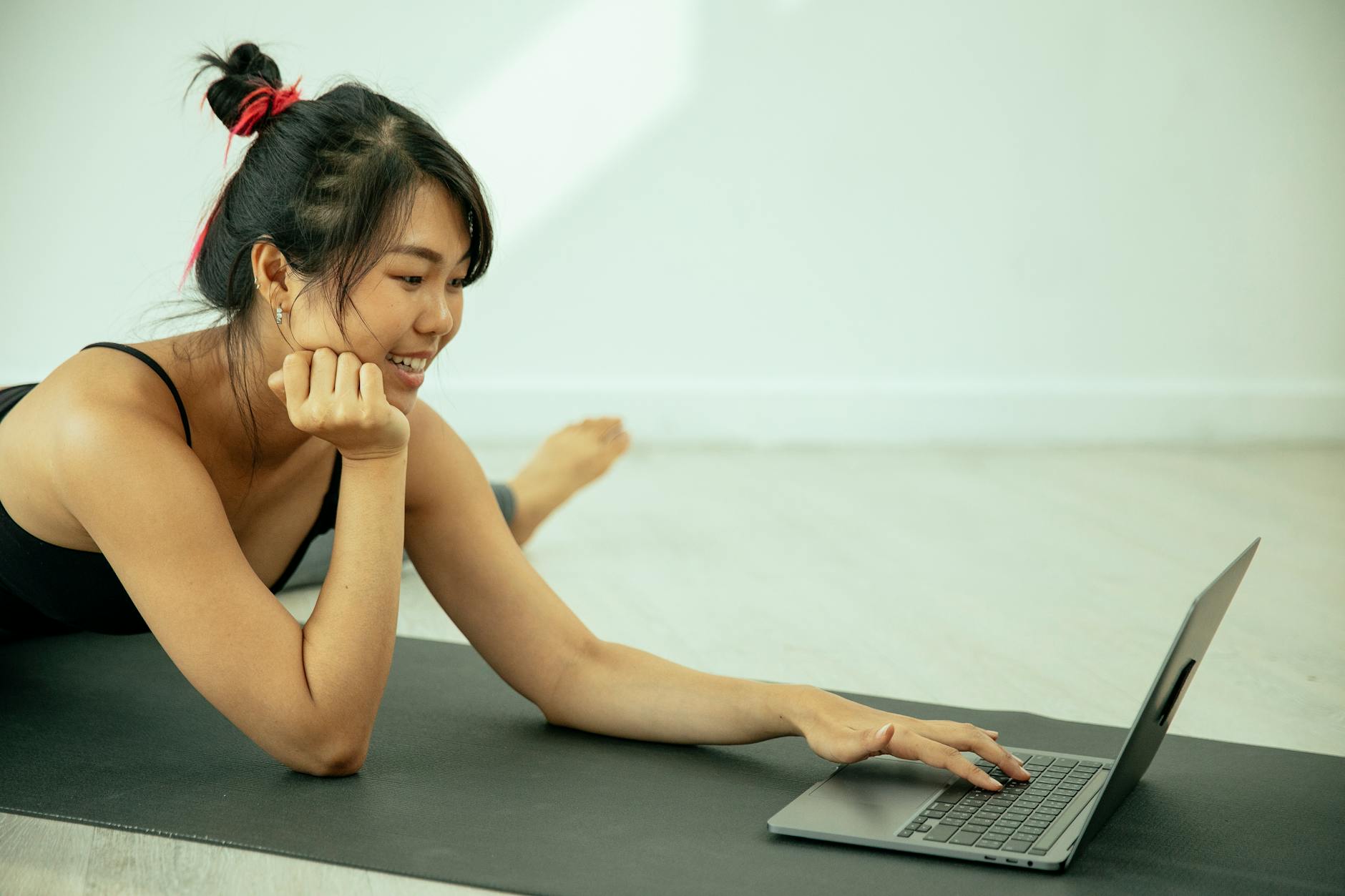 Asian woman using laptop on mat
