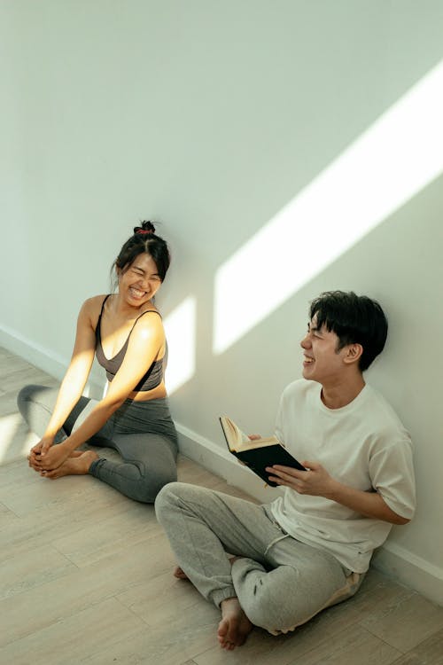 Free Cheerful Asian couple sitting on floor Stock Photo
