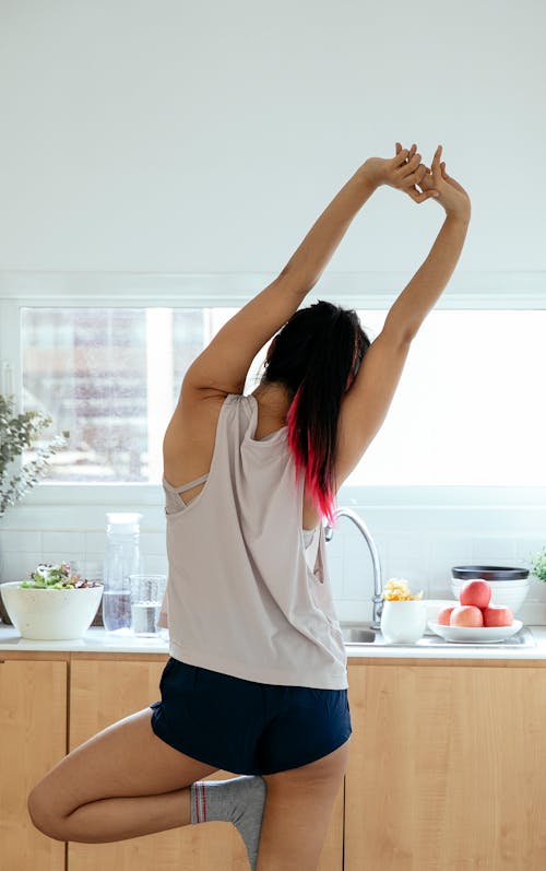 Free Anonymous woman doing tree pose Stock Photo