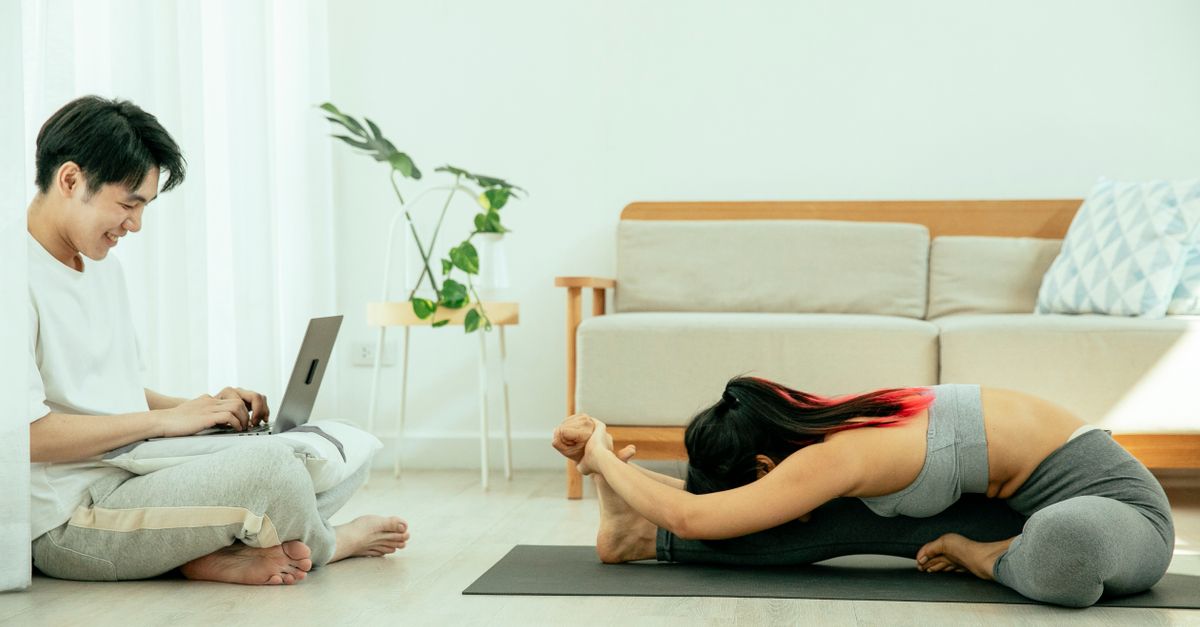 Person Working Out While Using Computer Man Using a Laptop in Front of a Woman Working Out · Free Stock Photo