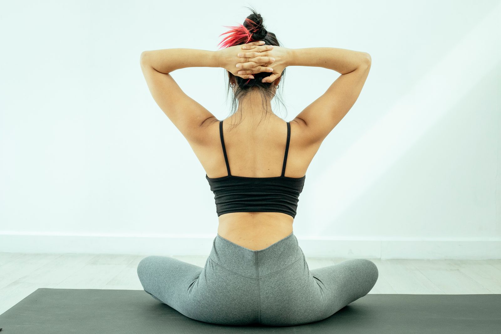 Person holding their lower back outdoors in bright daylight