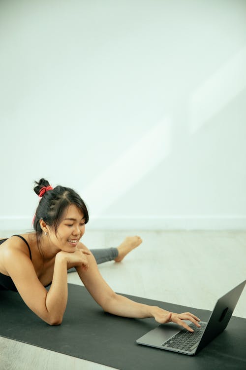 Free Asian woman using laptop on mat Stock Photo