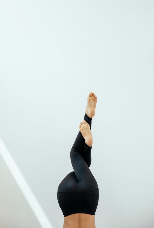 Crop unrecognizable woman practicing balance yoga pose