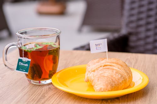 Free Cup of Tea Beside a Bread on Yellow Plate  Stock Photo
