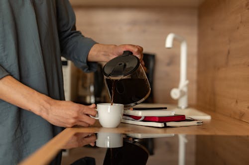 Free Person Pouring Coffee on a White Mug  Stock Photo