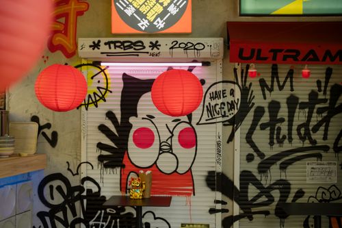 Free Urban Chinatown decor with graffiti, red lanterns, and Maneki Neko charm for a vibrant cultural ambiance. Stock Photo