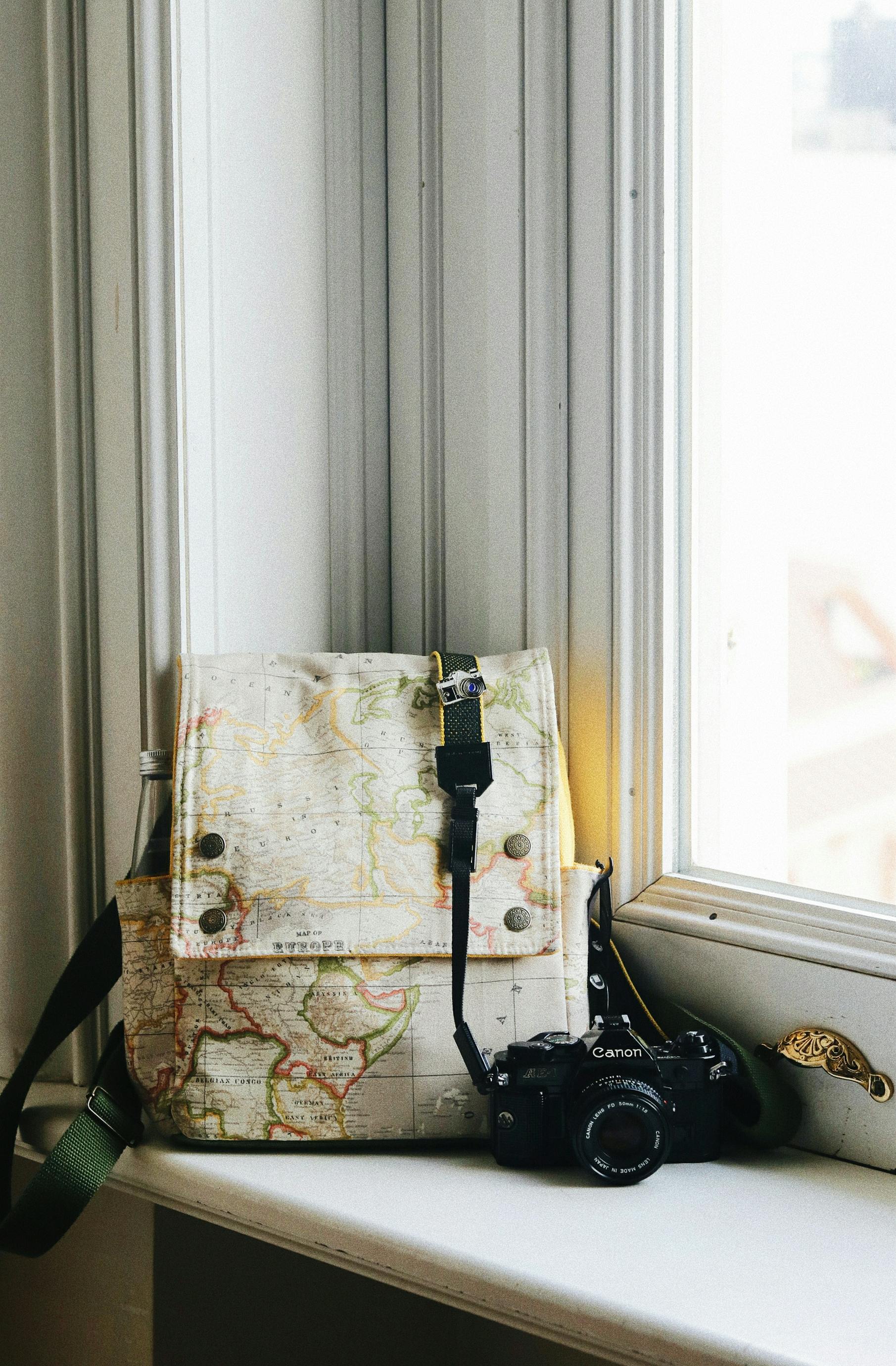 retro photo camera with backpack on windowsill