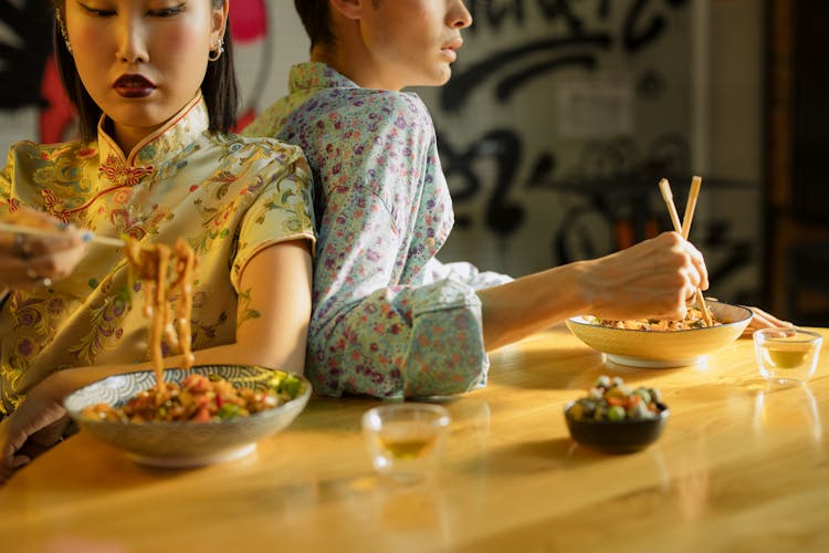 Man And Woman Eating Bowl Of Noodles