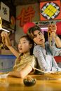 Man and Woman Holding Noodles with their Hands