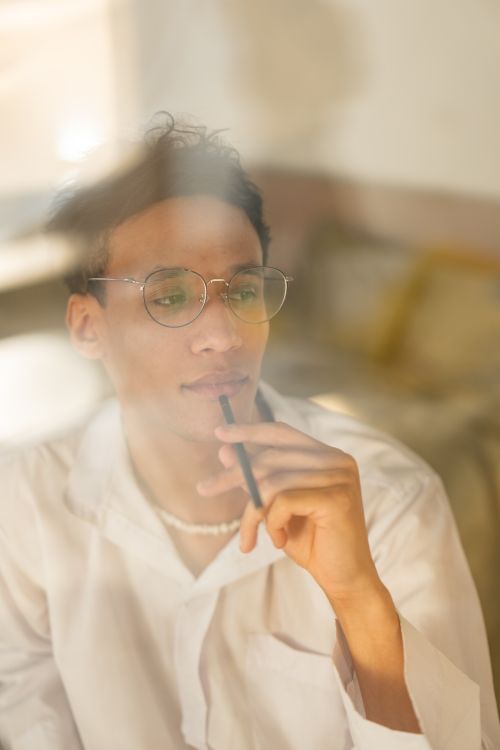 Free A serious man in white shirt thinking pensively indoors. Stock Photo
