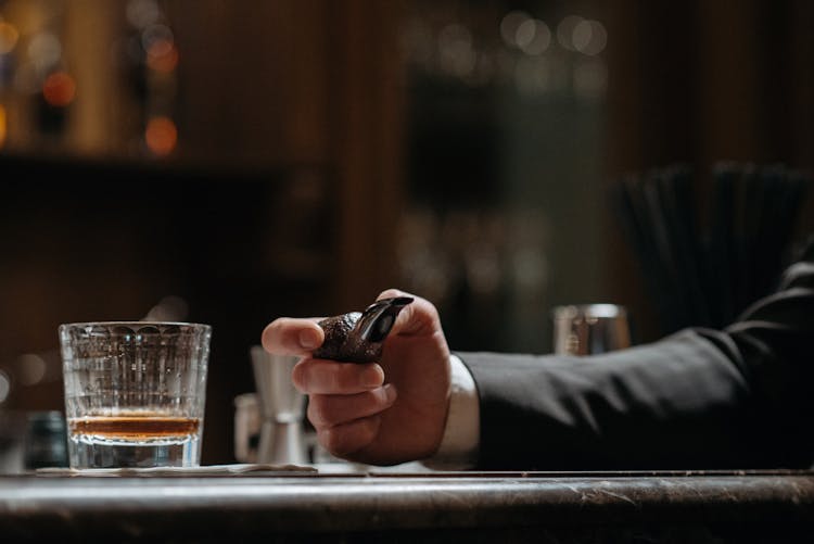 Person Holding A Tobacco Pipe