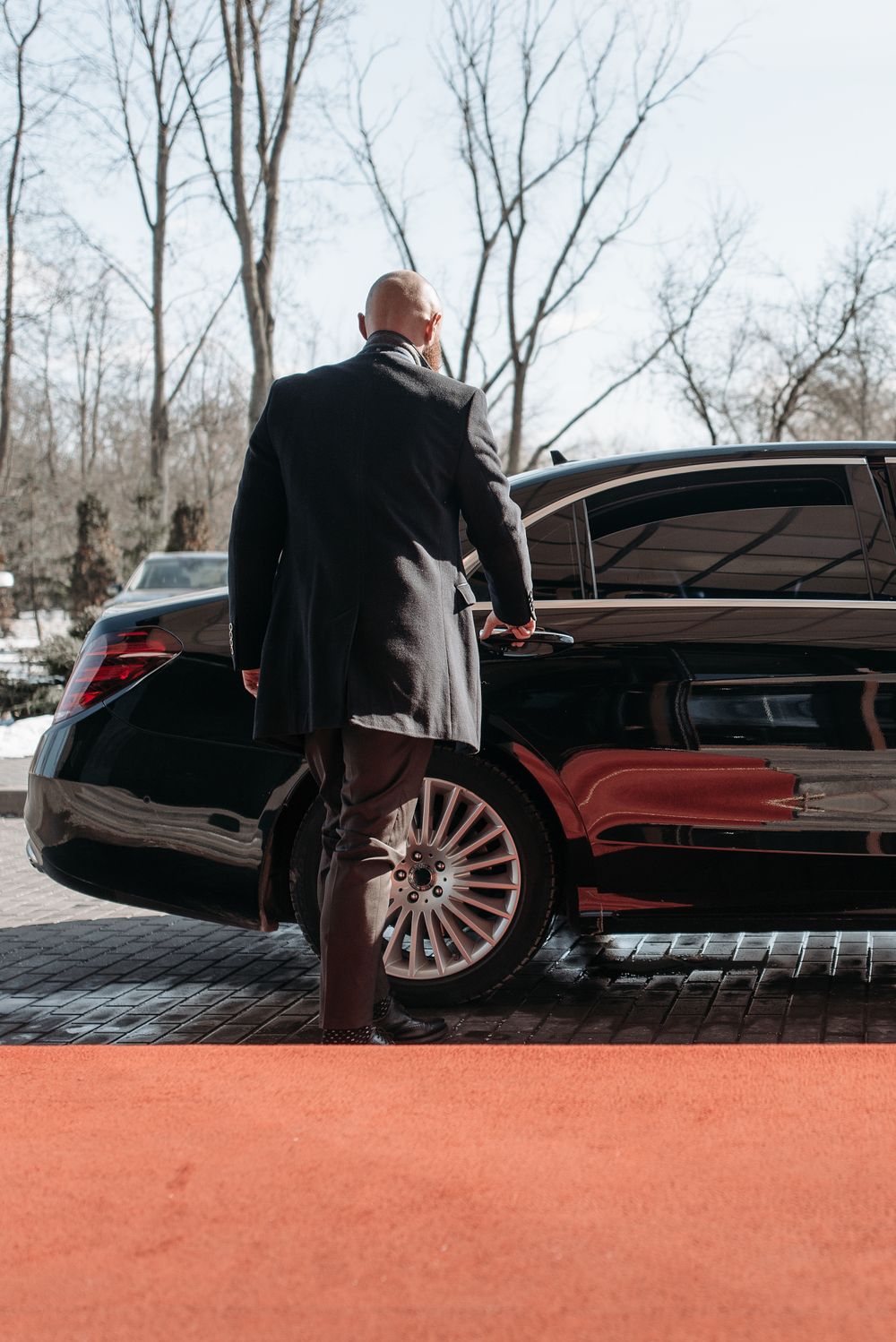 Garde du corps près d'une voiture de luxe