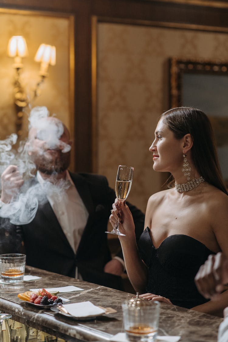 A Woman In Black Tube Dress Holding A Glass Of Wine