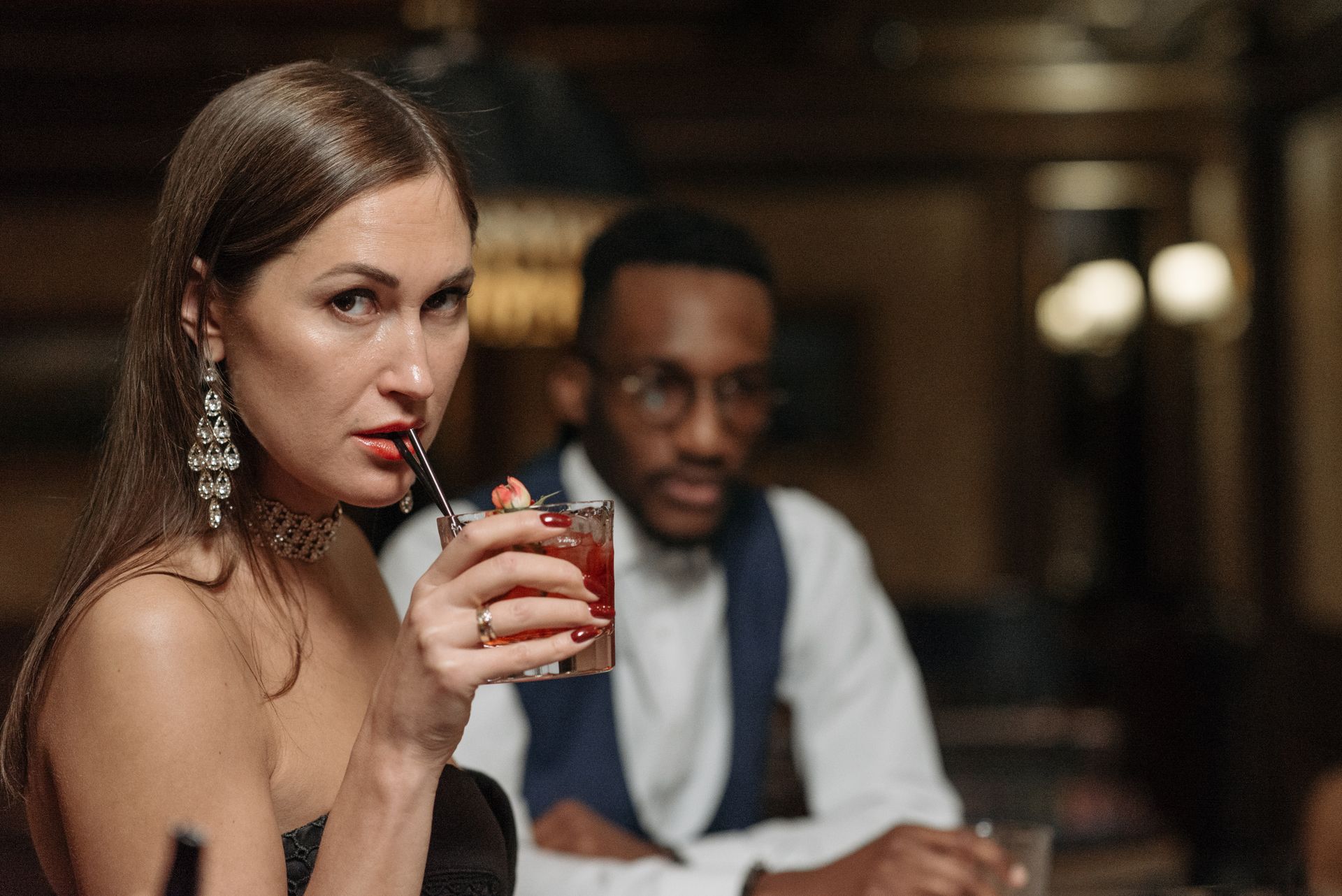 Sophisticated woman enjoying a cocktail in an upscale bar setting.