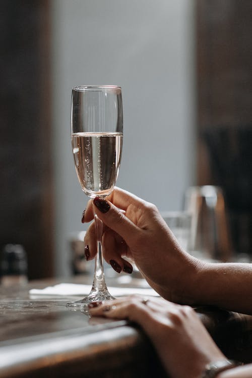 A Person Holding Clear Glass with White Wine