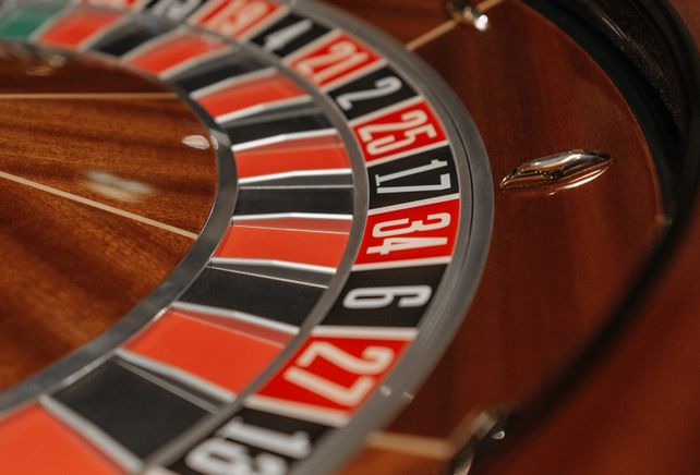Glücksspieler am Spielautomaten mit Münzen und Chips