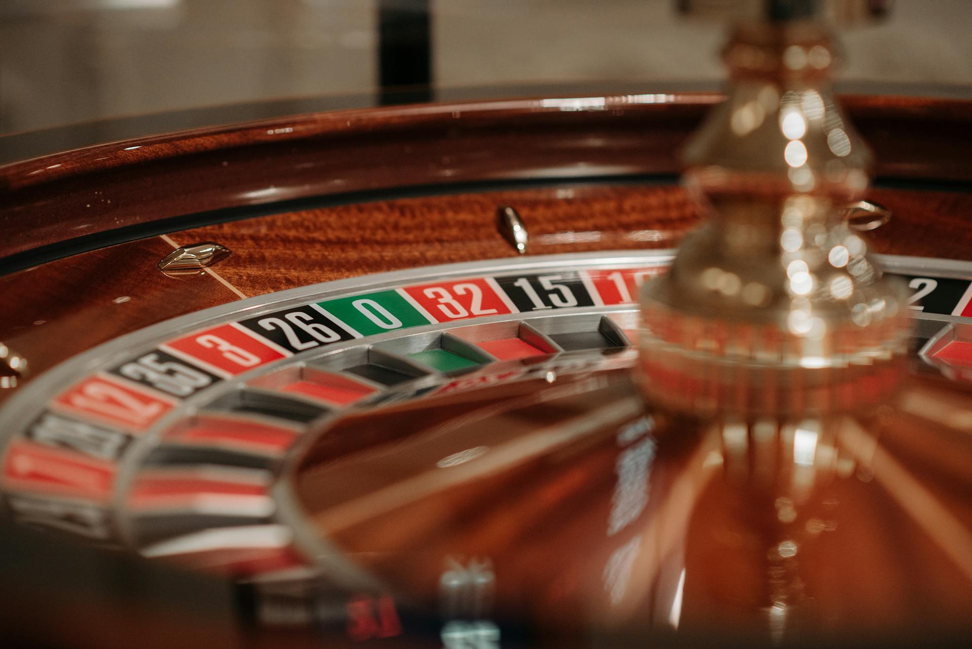 Detailed view of a spinning roulette wheel in a casino setting, showcasing numbers and colors.